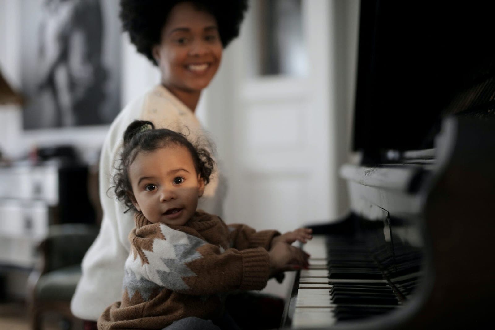 A parent and child enjoying a piano together