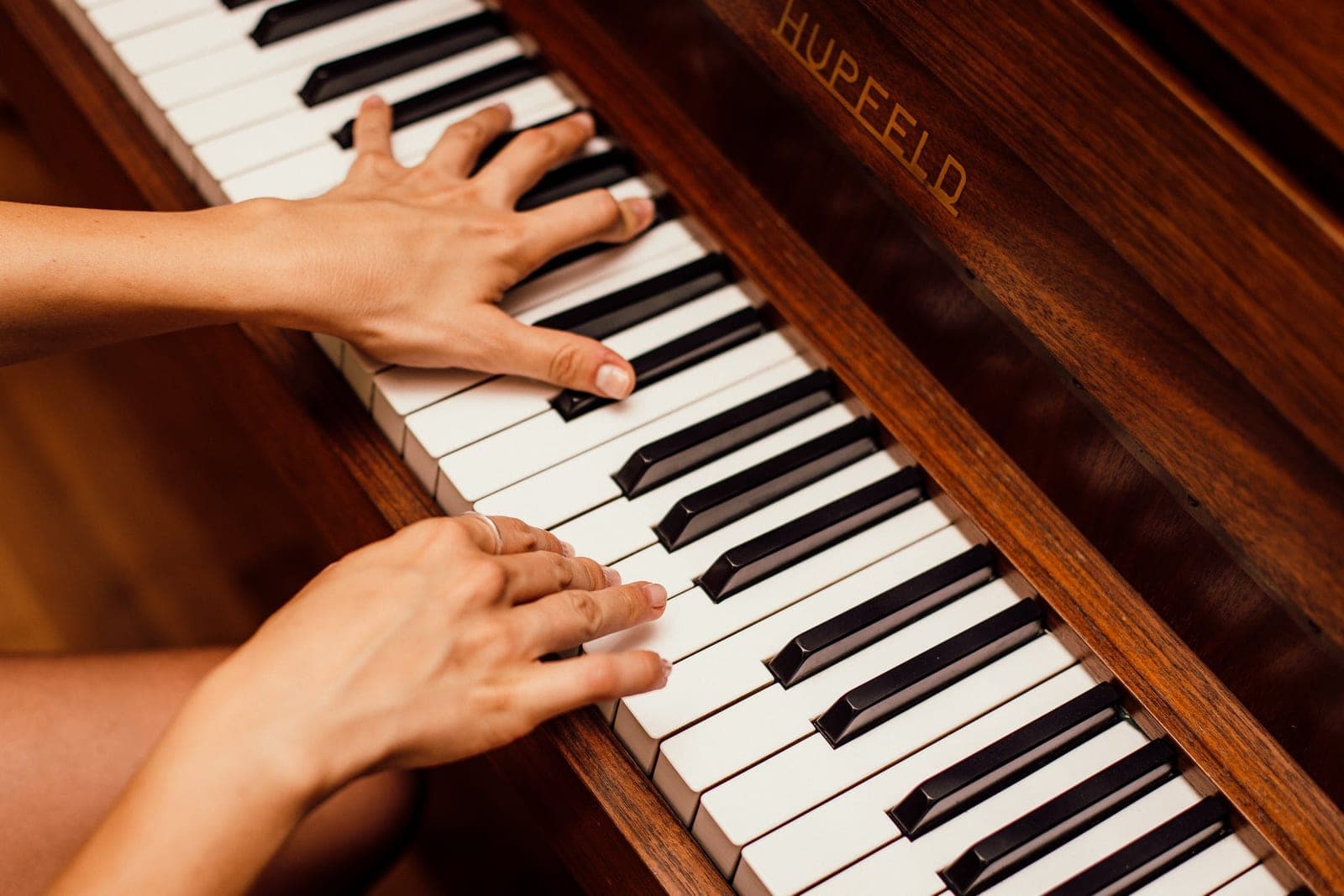 Hands playing a grand piano